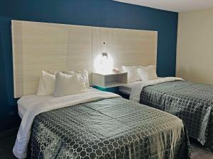 2 Betten in einem Hotelzimmer mit blauen Wänden in der Unterkunft Quality Inn & Suites McDonough South I-75 in McDonough