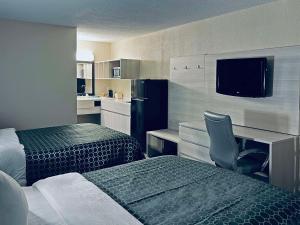 ein Hotelzimmer mit 2 Betten, einem Schreibtisch und einem Stuhl in der Unterkunft Quality Inn & Suites McDonough South I-75 in McDonough