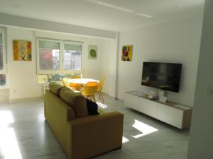 sala de estar con sofá y TV en Apartamento JARDIN DELUZ, con Wifi y Parking privado gratis, en Santander
