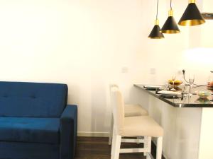 ein Wohnzimmer mit einem blauen Sofa und einem Tisch in der Unterkunft G 0.9 - G.oogle Nest Smart House in Braga