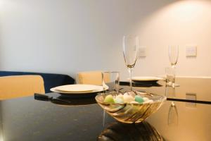 einen Tisch mit einer Schale Eier und Weingläsern in der Unterkunft G 0.9 - G.oogle Nest Smart House in Braga