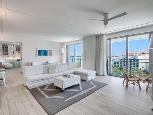 a living room with white furniture and a large window at SLS at Baha Mar in Nassau