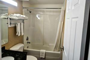 y baño con ducha, aseo y lavamanos. en Rodeway Inn & Suites, en Kamloops