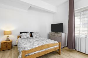 a bedroom with a bed and a flat screen tv at Fréjus Base Nature in Fréjus