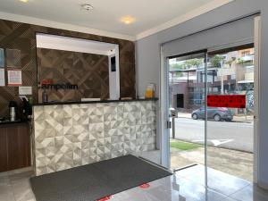 uma porta aberta para uma cozinha com uma parede de azulejos em Hotel Campolim em Sorocaba