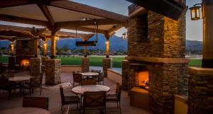 a patio with tables and chairs and a fireplace at La Quinta Resort & Club, Curio Collection in La Quinta