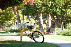 ein gelbes Fahrrad auf dem Rasen in einem Park in der Unterkunft La Quinta Resort & Club, Curio Collection in La Quinta