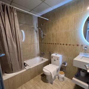 a bathroom with a toilet and a tub and a sink at Jumeirah lake towers in Dubai