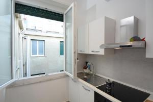 a kitchen with a sink and a window at Piazza Della Vittoria Apartment in Genoa