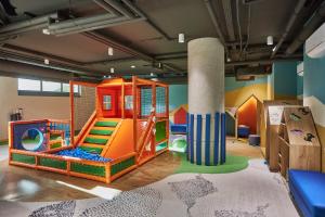 a childrens play room with a slide and a playground at Wave - Aurum II Apartment - Front Sea View in Międzyzdroje