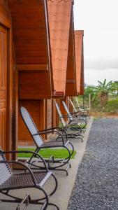 a row of chairs lined up next to a building at Chalés Carrara in Alto Paraíso de Goiás