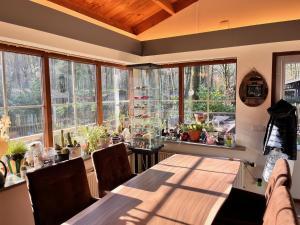 ein großer Raum mit einem Tisch und vielen Fenstern in der Unterkunft Vakantiechalet voor 4 plus 2 met sauna in Lanaken