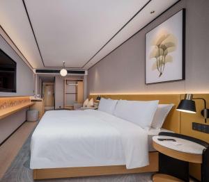 um quarto com uma grande cama branca e uma mesa em Hilton Garden Inn Beijing Temple Of Heaven East Gate Station em Pequim