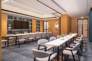 a conference room with tables and chairs and a screen at Hilton Garden Inn Beijing Temple Of Heaven East Gate Station in Beijing