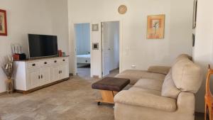 a living room with a couch and a flat screen tv at Casa Poniente in Chiclana de la Frontera