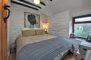 1 dormitorio con 1 cama con una pintura en la pared en Finest Retreats - Bwthyn Siabod, en Dolwyddelan