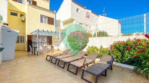 a patio with chairs and a table and a building at Vila Shradhala V4 Vilamoura Marina by HsRentals in Vilamoura