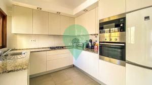 a kitchen with white cabinets and a stove top oven at Vila Shradhala V4 Vilamoura Marina by HsRentals in Vilamoura