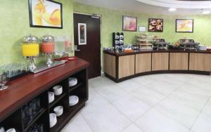 a restaurant with a counter with drinks and food at Wyndham Garden Monterrey Aeropuerto in Monterrey