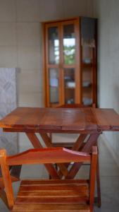 a wooden picnic table with a bench and a door at Chalés Carrara in Alto Paraíso de Goiás