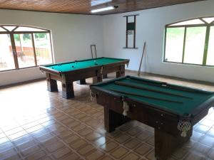 two pool tables in a room with two windows at Sitio in Pinhalzinho