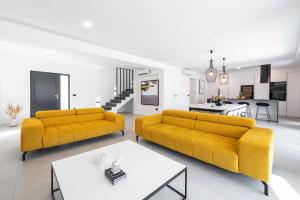 sala de estar con 2 sofás amarillos y cocina en Hillside Rest, en Čelopeci