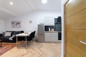 ein Wohnzimmer mit einem Tisch und einer Küche in der Unterkunft Orange Rentals- Loft Studio, City Centre Liverpool, Sleeps 4 guests in Liverpool