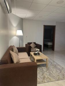 a living room with a couch and a coffee table at الساعه 60 للشقق المخدومه in Dammam