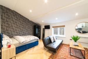 ein Schlafzimmer mit einem Bett, einem Stuhl und einem Spiegel in der Unterkunft Orange Rentals- Loft Studio, City Centre Liverpool, Sleeps 4 guests in Liverpool