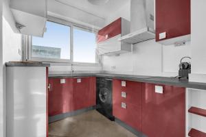 cocina con armarios rojos y lavadora en Toit des Rêves - Parking - Stadium, en Toulouse
