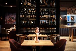 - un restaurant avec 2 tables et des bouteilles de vin dans l'établissement Bergmannsgata 3, à Røros