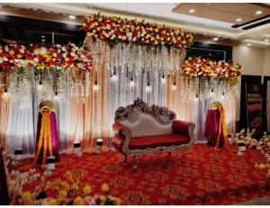 een kamer met een bank en bloemen en gordijnen bij Hotel Silver Arcade Premier, Malda, WB in Māldah