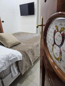 - une chambre dotée d'un lit avec une horloge murale dans l'établissement B&B TERRONIA, à Naples
