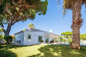 ein weißes Haus mit einer Palme in der Unterkunft Charming Vale do Lobo Villa - 4 Bedrooms - Villa Quadradinhos 22 - Private Pool and Close to Amenities - Algarve in Almancil