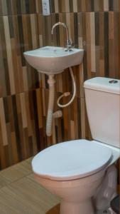 a bathroom with a toilet and a sink at Chalés Carrara in Alto Paraíso de Goiás
