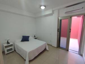 una camera bianca con un letto e una finestra di CASA QUINO EL PARQUE a Puerto de Mogán