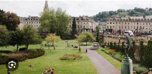 a park in a city with people sitting on the grass at The Nest in Keynsham