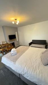 een slaapkamer met een groot wit bed en een tafel bij Family room, Shared House in Bristol