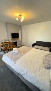 um quarto com uma grande cama branca e uma mesa em Family room, Shared House em Bristol