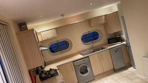 una pequeña cocina con lavadora y secadora. en Free parking near city centre & stadium sleeps 6-8 en Leicester