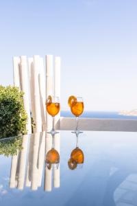 two wine glasses sitting on top of a pool at Margarita House in Mýkonos City