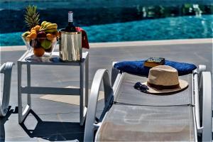 a table with a bottle of wine and a hat on it at Xenos Villa 1 in Tigaki