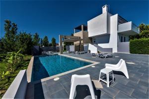 a villa with a swimming pool in front of a house at Xenos Villa 1 in Tigaki