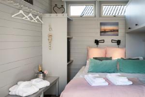 a bedroom with a pink bed with towels on it at Strandflickornas Husen invid Havet in Lysekil