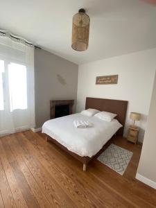 een witte slaapkamer met een bed en een open haard bij Le bon coin in Le Creusot