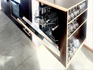 um armário cheio de pratos e utensílios em Loft mit Dachterrasse em Bernau am Chiemsee