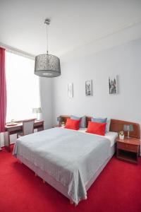 1 dormitorio con 1 cama blanca grande con almohadas rojas en Elegant & Stylish Center Apartments!, en Praga