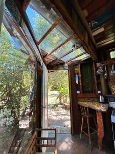 eine Außenansicht einer Hütte mit einem Tisch und einem Fenster in der Unterkunft Casa Barco Campeche in Florianópolis