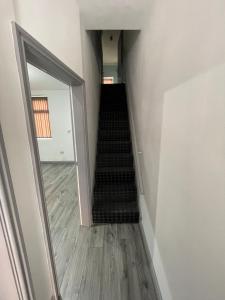 a hallway with a staircase with a mirror and a stair case at Luxurious En-suite Room 4 in Manchester