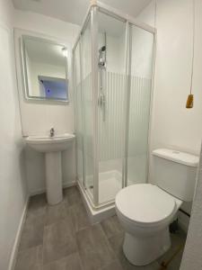 a bathroom with a shower and a toilet and a sink at The New Athena Hotel in Blackpool